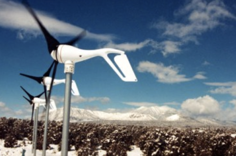 Row of Southwest Windpower small wind turbines on a snowy high-desert ridge