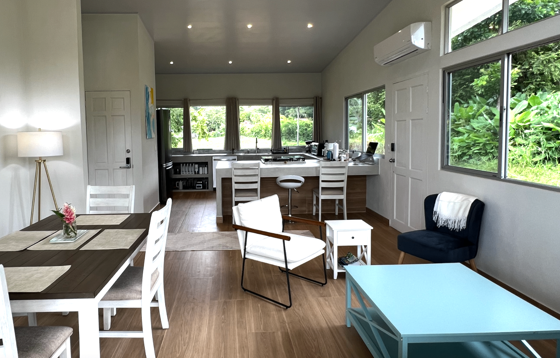 Bright interior of Casa Ojochal with vaulted ceilings, open kitchen and living area, and wide windows looking out into the surrounding jungle